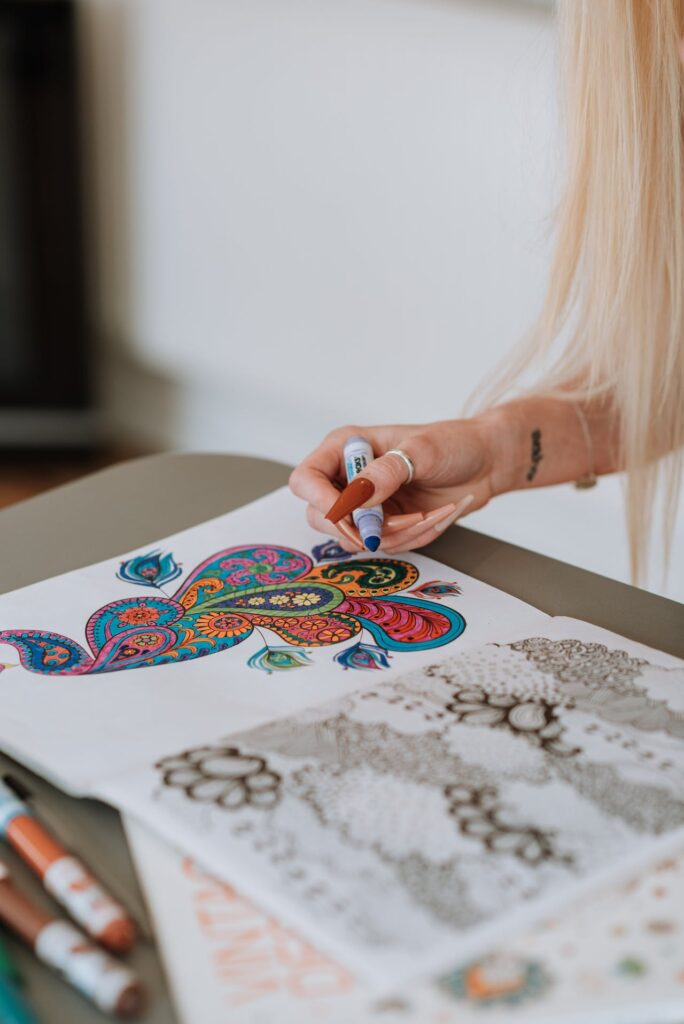 Lady coloring in Mandala Coloring Book for calming mindful coloring